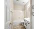 Bathroom featuring a tub/shower combo, white vanity with black hardware and wood look flooring at 13857 W Windsor Ave, Goodyear, AZ 85395