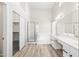 Bright bathroom featuring double vanity, soaking tub, glass-enclosed shower, and walk-in closet at 13857 W Windsor Ave, Goodyear, AZ 85395