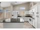 Bright kitchen boasts white cabinetry, stainless steel appliances, dark countertops, and ample natural light at 13857 W Windsor Ave, Goodyear, AZ 85395
