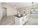 Kitchen island with black countertops and white cabinets adjacent to living area and dining area at 13857 W Windsor Ave, Goodyear, AZ 85395