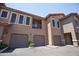 Charming townhome exterior featuring multiple garages, neutral paint, and a well-kept landscape at 14250 W Wigwam Blvd # 522, Litchfield Park, AZ 85340