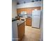 Functional kitchen featuring light wood cabinets, appliances, tile flooring, and black countertops at 14250 W Wigwam Blvd # 522, Litchfield Park, AZ 85340