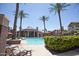 Resort-style pool and clubhouse, surrounded by lush landscaping and palm trees at 14250 W Wigwam Blvd # 522, Litchfield Park, AZ 85340