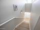Staircase with neutral walls, light wood steps and risers, white handrail, and natural light near the doorway at 14250 W Wigwam Blvd # 522, Litchfield Park, AZ 85340