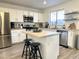 Well-lit kitchen with stainless steel appliances, island with seating, and white cabinetry at 1469 S Boulder St # C, Gilbert, AZ 85296