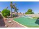 The manicured backyard features a pool,putting green, and desert landscaping at 1564 E Leaf Rd, San Tan Valley, AZ 85140