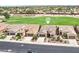 Aerial view of a well-maintained neighborhood showcasing lush green golf course, desert landscaping, and tile roof homes at 16077 W Vale Dr, Goodyear, AZ 85395