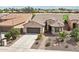 Aerial view of a well-maintained property showcasing desert landscaping, garage, and front entrance at 16077 W Vale Dr, Goodyear, AZ 85395