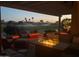 A cozy back patio with a fire table and views of the golf course is perfect for entertaining guests at 16077 W Vale Dr, Goodyear, AZ 85395