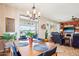 Bright dining room features a modern chandelier, table with seating for four, and large sliding doors to backyard at 16077 W Vale Dr, Goodyear, AZ 85395