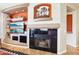 Close-up of modern fireplace with decorative shelving, desert-themed art, and seamless flow into the next room at 16077 W Vale Dr, Goodyear, AZ 85395