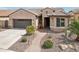 Charming single-story home with a landscaped walkway, desert plants, and a two-car garage at 16077 W Vale Dr, Goodyear, AZ 85395