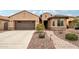 Charming single-story home with a three-car garage, landscaped front yard, and a welcoming brick walkway at 16077 W Vale Dr, Goodyear, AZ 85395