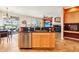 View of the kitchen with stainless steel appliances, wooden cabinets, and breakfast bar with a black countertop at 16077 W Vale Dr, Goodyear, AZ 85395