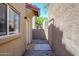 Side yard pathway showcases concrete and gravel leading to a door and textured facade at 17610 N 17Th Pl # 2, Phoenix, AZ 85022