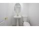 Stylish powder room featuring a pedestal sink with gold hardware and a round mirror, offering a chic design at 17610 N 17Th Pl # 2, Phoenix, AZ 85022
