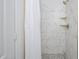 Modern shower with marble-look tiles, a rainfall showerhead, and gold accents, offering a luxurious feel at 17610 N 17Th Pl # 2, Phoenix, AZ 85022