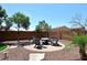Backyard fire pit area surrounded by mature trees and a block wall at 18351 W Southgate Ave, Goodyear, AZ 85338