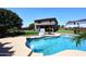 Expansive backyard featuring a pool, artificial grass, mature trees, and an outdoor entertainment area at 18351 W Southgate Ave, Goodyear, AZ 85338