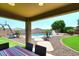 Covered patio view of the pool, water slide, and artificial turf at 18351 W Southgate Ave, Goodyear, AZ 85338