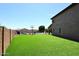 Lush backyard with a vast artificial grass area, showcasing a pool, an outdoor seating area, and a basketball hoop at 18351 W Southgate Ave, Goodyear, AZ 85338