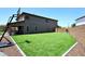 Well-maintained backyard showcasing artificial grass, basketball hoop, and lush greenery, ideal for outdoor activities at 18351 W Southgate Ave, Goodyear, AZ 85338