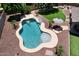 An aerial view of the backyard showing a freeform pool, spa, lounge area, and artificial grass at 18351 W Southgate Ave, Goodyear, AZ 85338