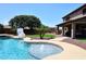 Beautiful backyard with pool, artificial grass area, patio, and outdoor kitchen, perfect for relaxing and entertaining at 18351 W Southgate Ave, Goodyear, AZ 85338