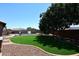 Artificial turf area with a view of the pool, basketball court, and mature trees at 18351 W Southgate Ave, Goodyear, AZ 85338