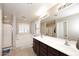 Bright bathroom featuring double sinks, a large mirror, and a separate tub and shower at 18351 W Southgate Ave, Goodyear, AZ 85338