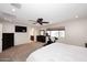 Large bedroom with mounted TV, ceiling fan, exercise equipment, and ensuite bathroom at 18351 W Southgate Ave, Goodyear, AZ 85338