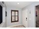 Bright entryway with neutral walls, dark wood window shutter, and a stylish white door at 18351 W Southgate Ave, Goodyear, AZ 85338