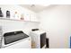 Functional laundry room featuring modern washer and dryer with storage shelves at 18351 W Southgate Ave, Goodyear, AZ 85338