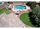 Aerial view of backyard pool with patio furniture, manicured lawn, and stylish striped umbrella at 18351 W Southgate Ave, Goodyear, AZ 85338
