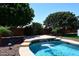 Stunning pool featuring a unique waterfall cascading down a stone wall with beautiful blue water at 18351 W Southgate Ave, Goodyear, AZ 85338