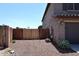 Side yard featuring a gated entrance and gravel, showcasing functional and private outdoor space at 18351 W Southgate Ave, Goodyear, AZ 85338
