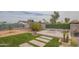 Spacious backyard offers a paved patio, artificial turf, firepit, and thoughtfully designed landscaping at 1861 N 63Rd Ave, Phoenix, AZ 85035