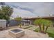 Landscaped backyard with a built-in grill, a fire pit, artificial turf, desert landscaping, and a covered patio at 1861 N 63Rd Ave, Phoenix, AZ 85035