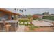 Beautiful backyard featuring a built-in outdoor kitchen, lush landscaping, firepit, and covered patio, perfect for entertaining at 1861 N 63Rd Ave, Phoenix, AZ 85035