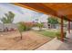 Large backyard area featuring a covered patio, outdoor kitchen and barbecue area, firepit, and green landscaping at 1861 N 63Rd Ave, Phoenix, AZ 85035