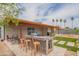 Enjoy outdoor living with a covered patio, outdoor kitchen area, lush grass, and mature palm trees at 1861 N 63Rd Ave, Phoenix, AZ 85035