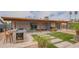 Spacious backyard with a built-in grill, covered patio, artificial turf, and desert landscaping at 1861 N 63Rd Ave, Phoenix, AZ 85035