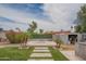 Landscaped backyard with artificial turf, desert landscaping, a built-in grill, and an outdoor kitchen at 1861 N 63Rd Ave, Phoenix, AZ 85035