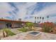 Well-maintained backyard featuring a fire pit, desert landscaping, artificial turf, and a covered patio at 1861 N 63Rd Ave, Phoenix, AZ 85035
