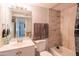 Tiled bathroom boasts a shower-over-tub with neutral color and functional design at 1861 N 63Rd Ave, Phoenix, AZ 85035