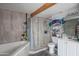 Well-lit bathroom featuring modern tiles, soaking tub, and glass-enclosed shower at 1861 N 63Rd Ave, Phoenix, AZ 85035