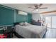 Comfortable bedroom features dark green walls and trim, a ceiling fan, and sliding glass doors to a patio area at 1861 N 63Rd Ave, Phoenix, AZ 85035