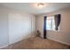 Neutral bedroom with carpet, closet, and a window with blue curtains, offering a simple and inviting space at 1861 N 63Rd Ave, Phoenix, AZ 85035