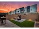 Modern backyard with cozy fire pit area, stylish patio furniture, and ambient string lighting at sunset at 1910 W Desert Hollow Dr, Phoenix, AZ 85085