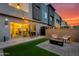 Backyard featuring modern patio furniture, a fire pit, artificial grass, and string lights for evening ambiance at 1910 W Desert Hollow Dr, Phoenix, AZ 85085